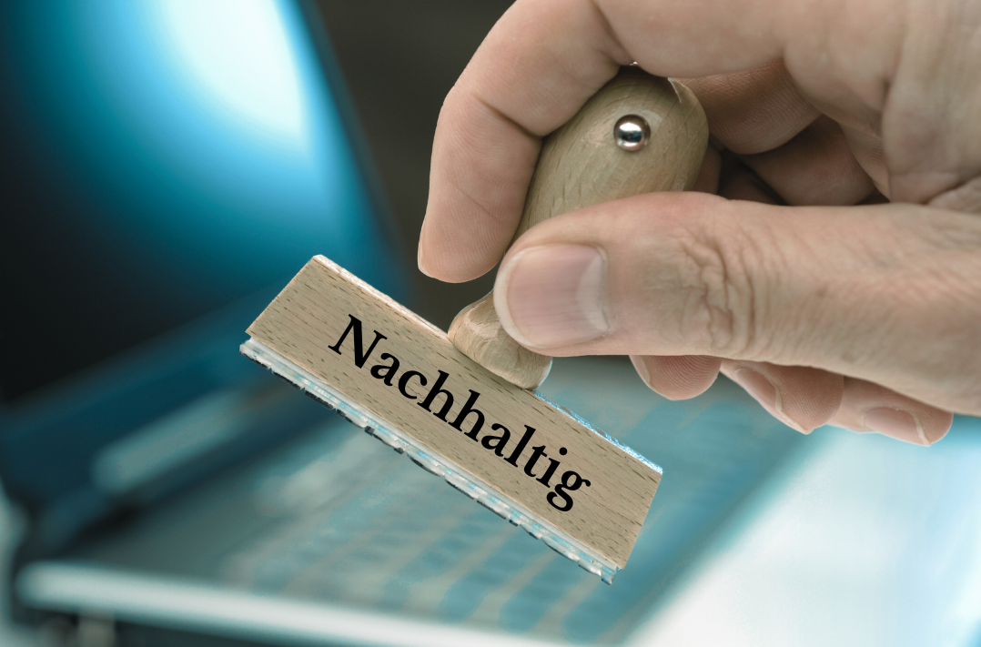 Das Bild zeigt eine Hand mit einem Stempel, auf dem das Wort 